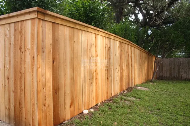 A flat cap and face trim finish the top of this wood privacy fence.