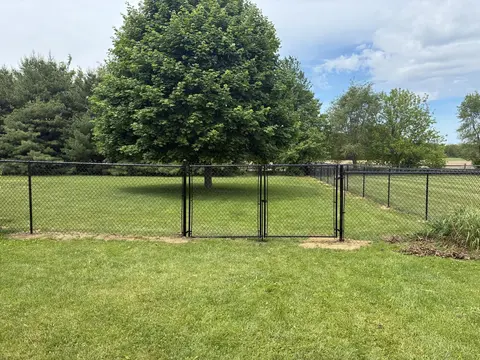 Two matching chain-link gate leaves create a wider opening.