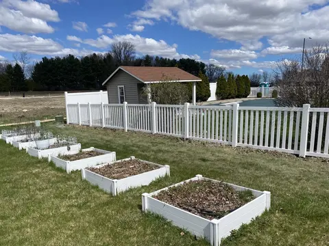 A continuous top rail caps the white vinyl pickets.
