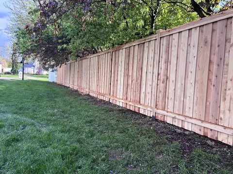 A flat top cap and horizontal trim frame the wood privacy boards.