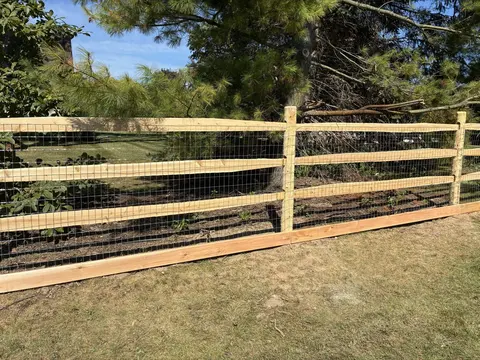 Wood rail fencing with wire mesh