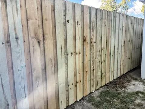 Close detail of pressure-treated dog-ear pickets