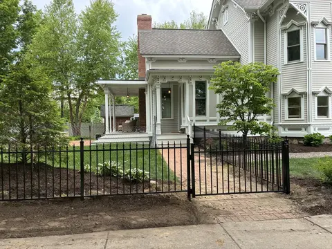Spear-top pickets continue across the ornamental fence and matching gate.