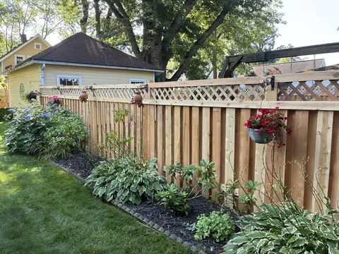 Diagonal lattice above vertical wood privacy boards.