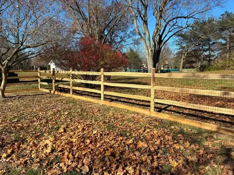 Wood rail fencing with wire mesh