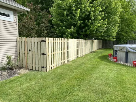 Alternating pickets on both sides of the rails create a shadowbox fence and gate.