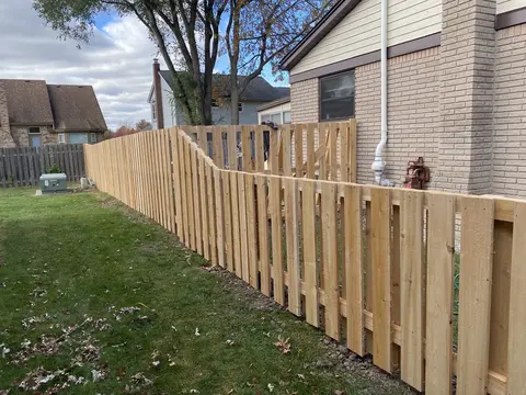 Wood fencing with a shaped top