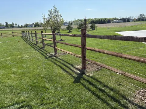Wood rail fencing with wire mesh