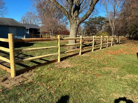 Wood rail fencing with wire mesh