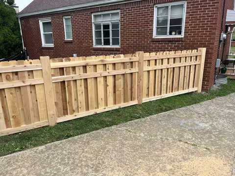 Wood shadowbox fence with alternating boards.