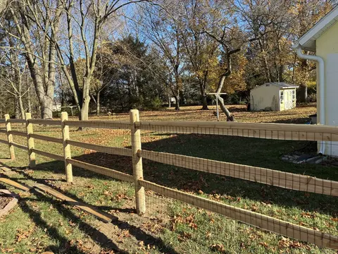 Wood rail fencing with wire mesh